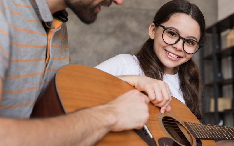 close-up-papa-ensenando-nina-tocar-guitarra_23-2148542815 close-up-papa-ensenando-nina-tocar-guitarra_23-2148542815